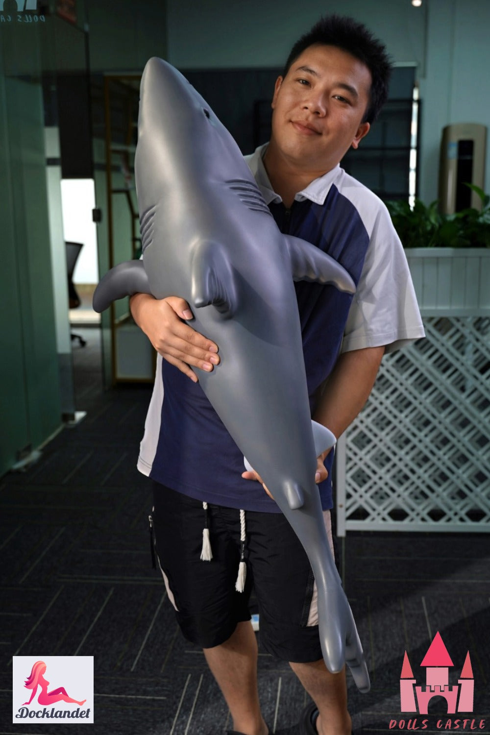 Shark Doll 110 cm is held in the arms to show size and proportions, realistic shark design with gray top and white bottom.