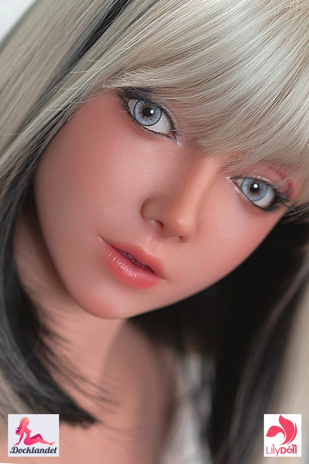 Närbild på realistisk sex docka från LilyDoll med platina‑blont hår med svarta slingor, stora blå ögon och mjuka rosa läppar realistiska drag och ljus hudton